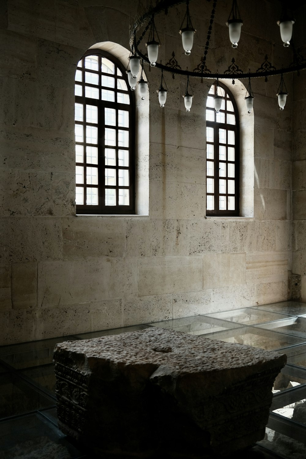 a stone bench in a room with three windows