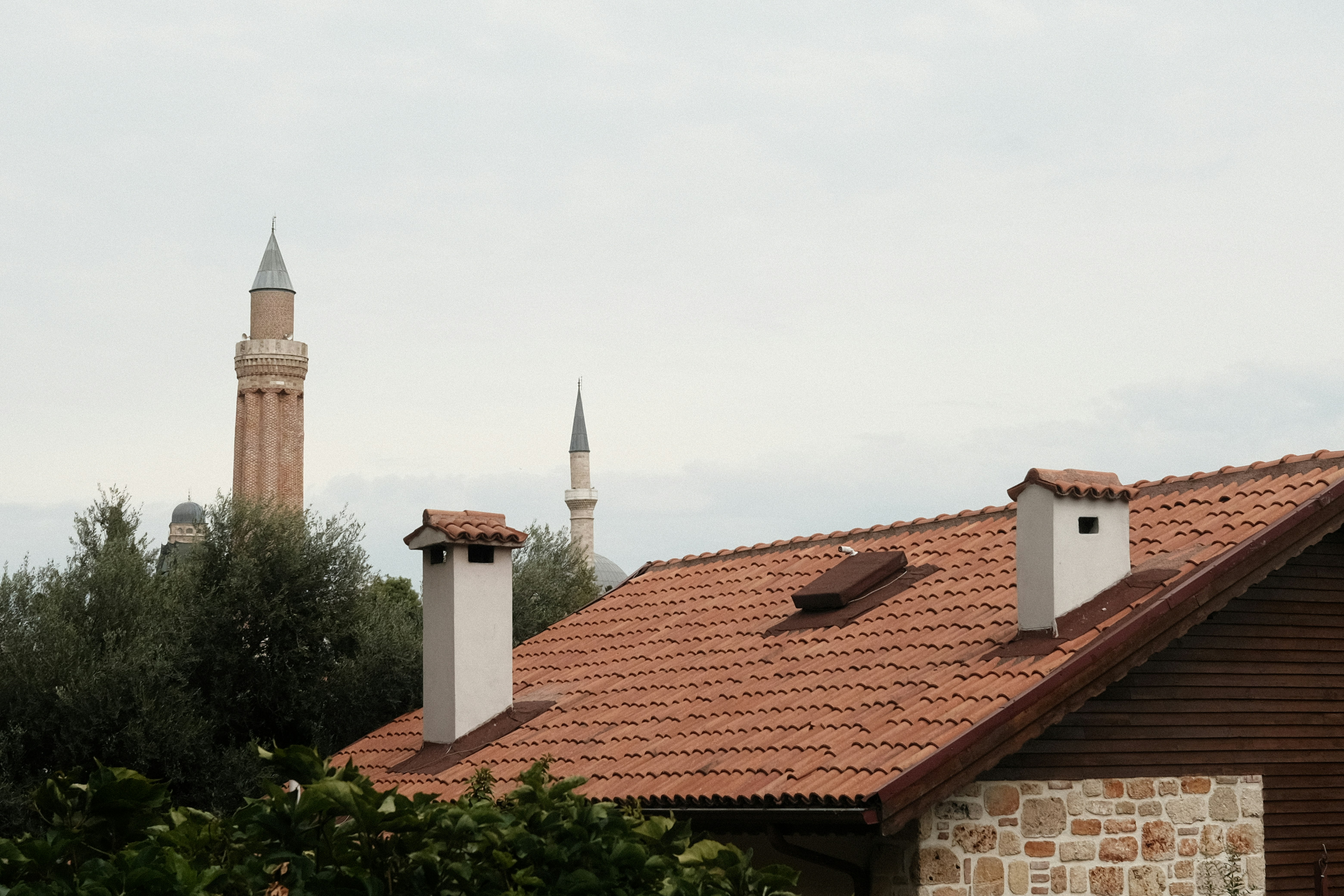 здание с двумя дымоходами и часовой башней на заднем плане