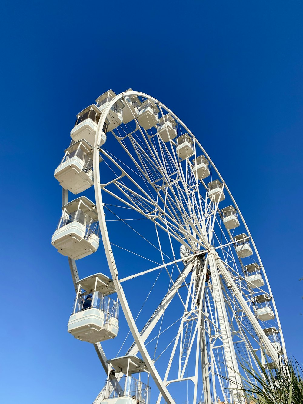 a white ferris wheel against a blue sky