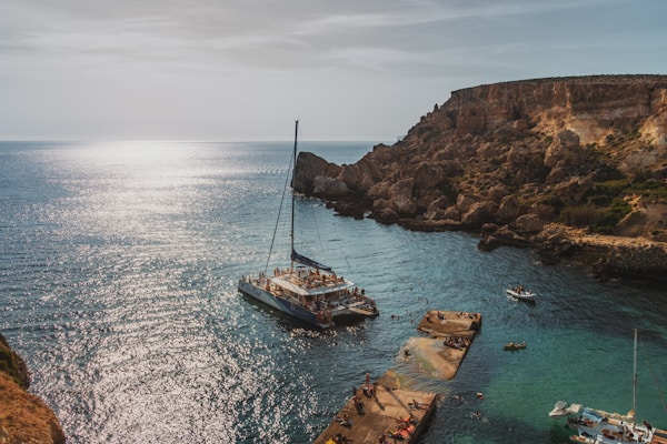 a boat in the water near a rocky cliff