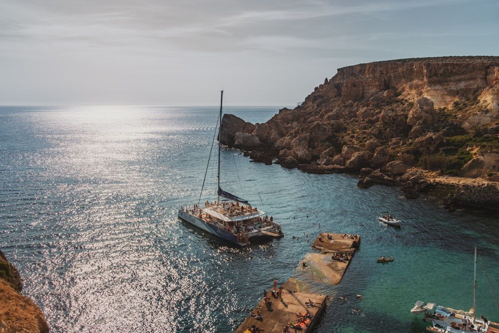 a boat in the water near a rocky cliff