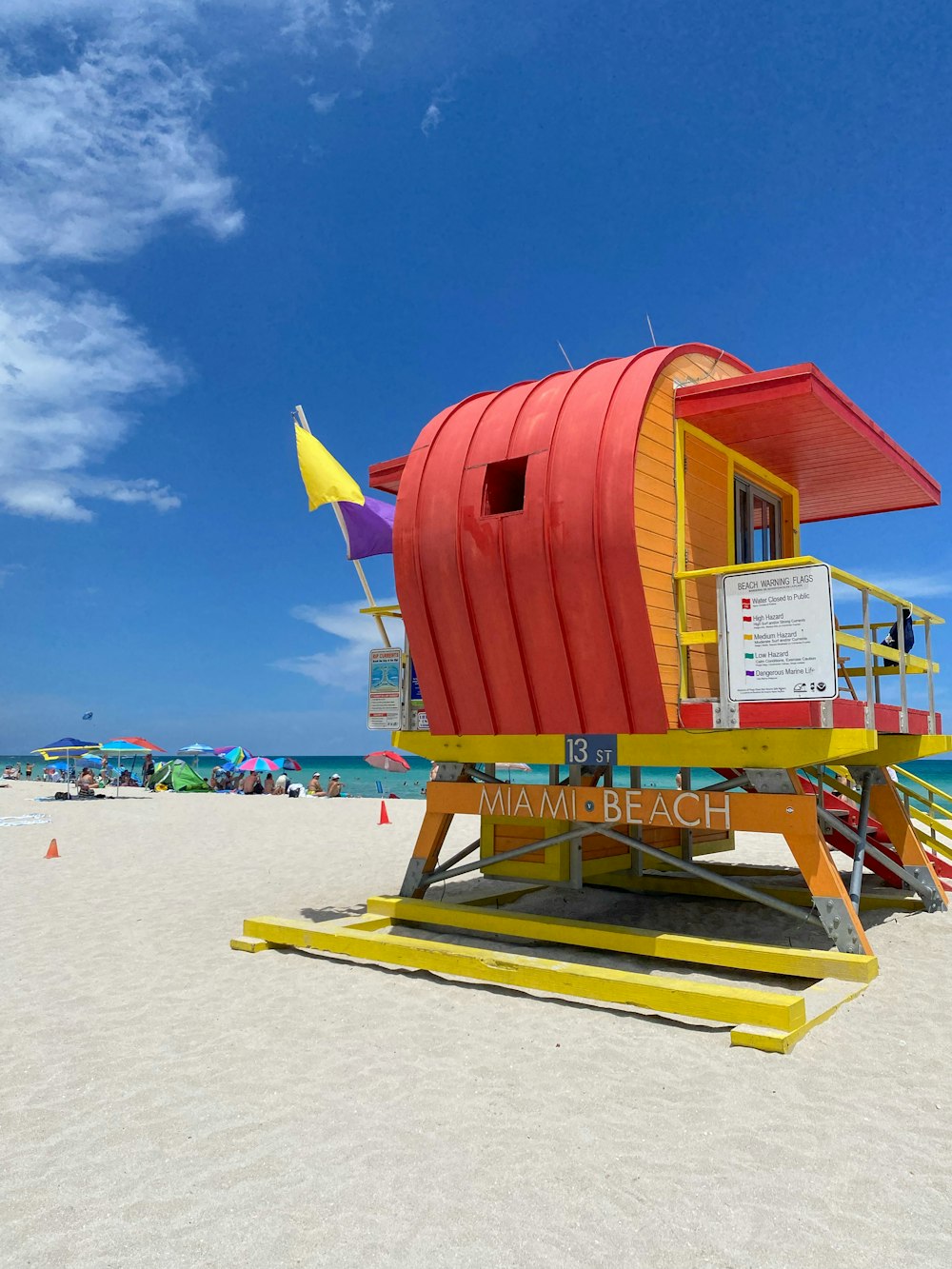 a lifeguard stand on the beach with a lifeguard flag
