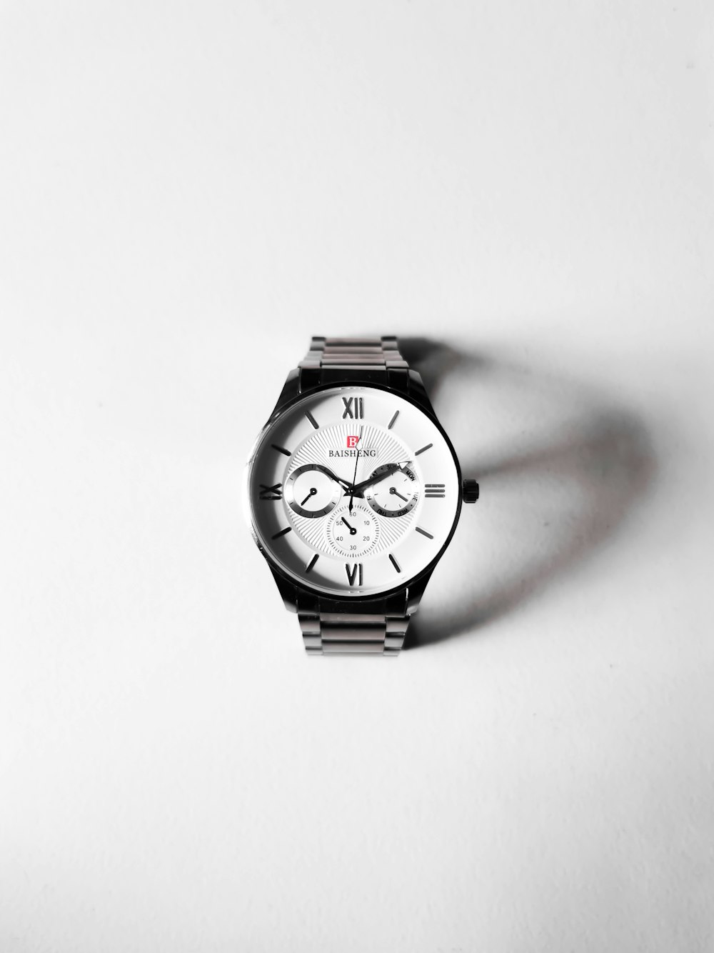 a watch sitting on top of a white table