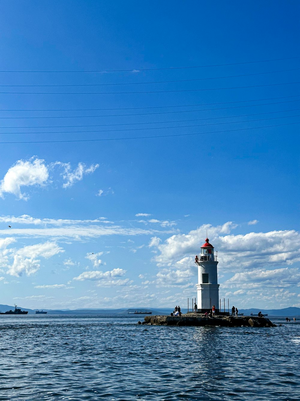 a lighthouse on a small island in the middle of the ocean