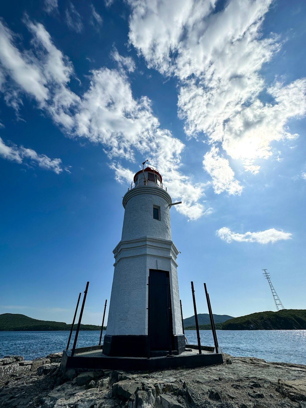 a white lighthouse sitting on top of a rocky beach