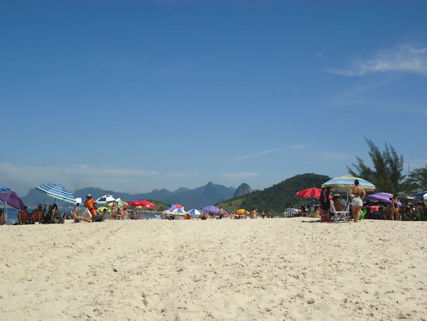 Golden sandy beaches of Goa with colorful umbrellas and people enjoying the sun.