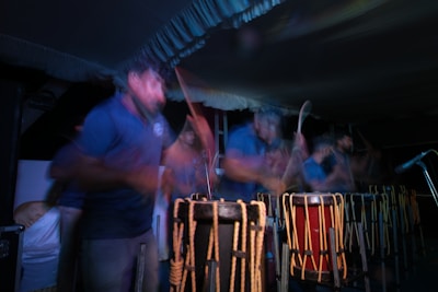 A vibrant close-up of hands playing traditional African drums under warm stage lights.
