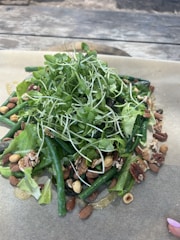 A vibrant salad featuring fresh mint leaves and crunchy walnuts atop mixed greens.