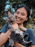 a woman holding a cat in her arms