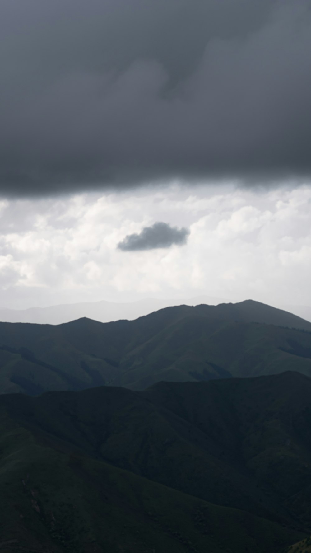 a view of a mountain range under a cloudy sky