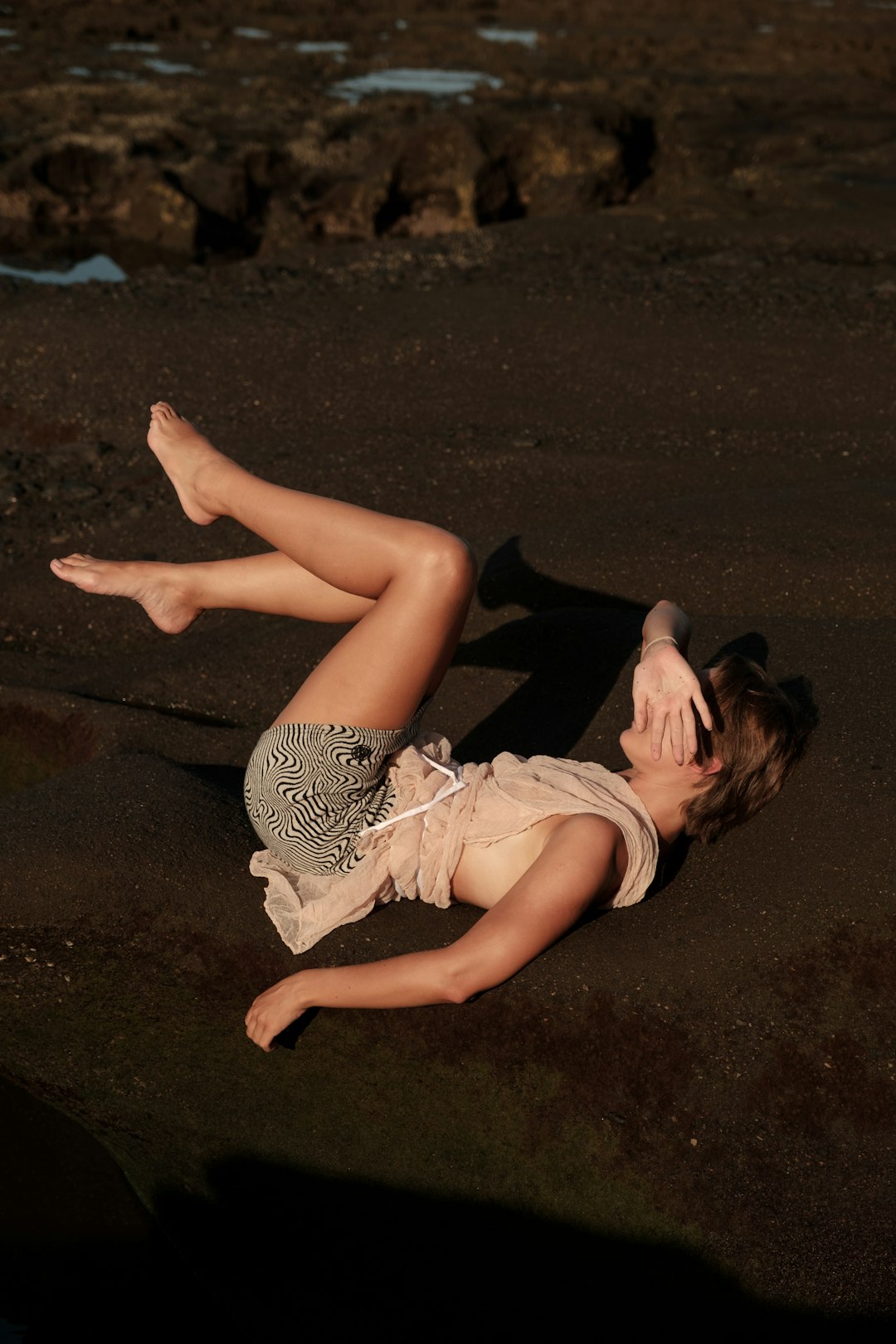 a woman laying on the ground with her legs crossed