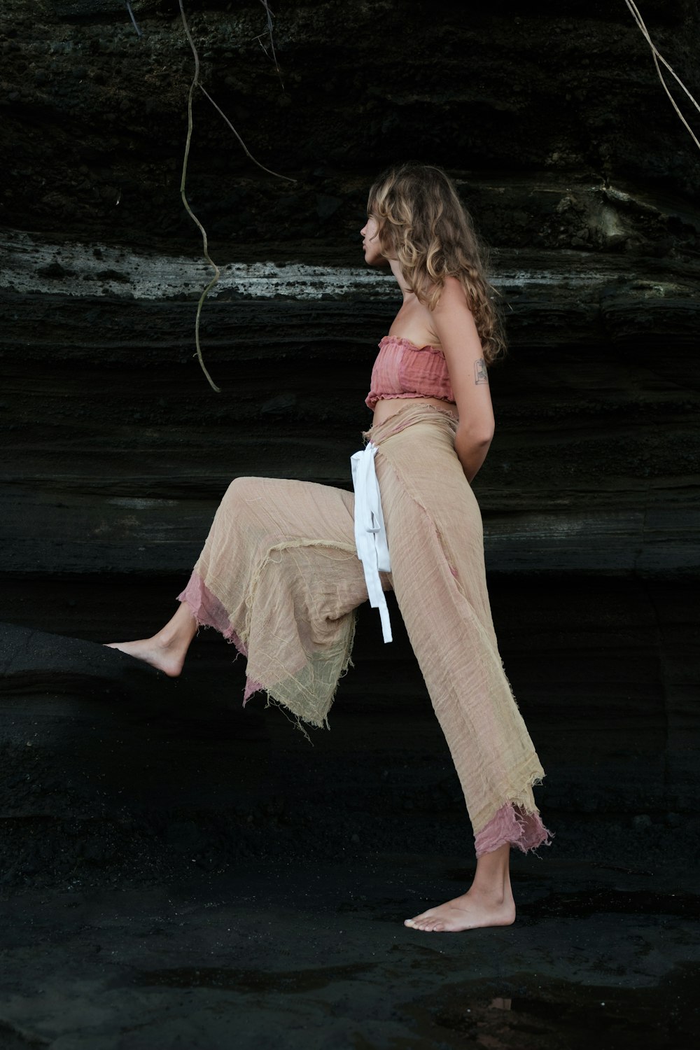 a woman sitting on a rock with her legs crossed