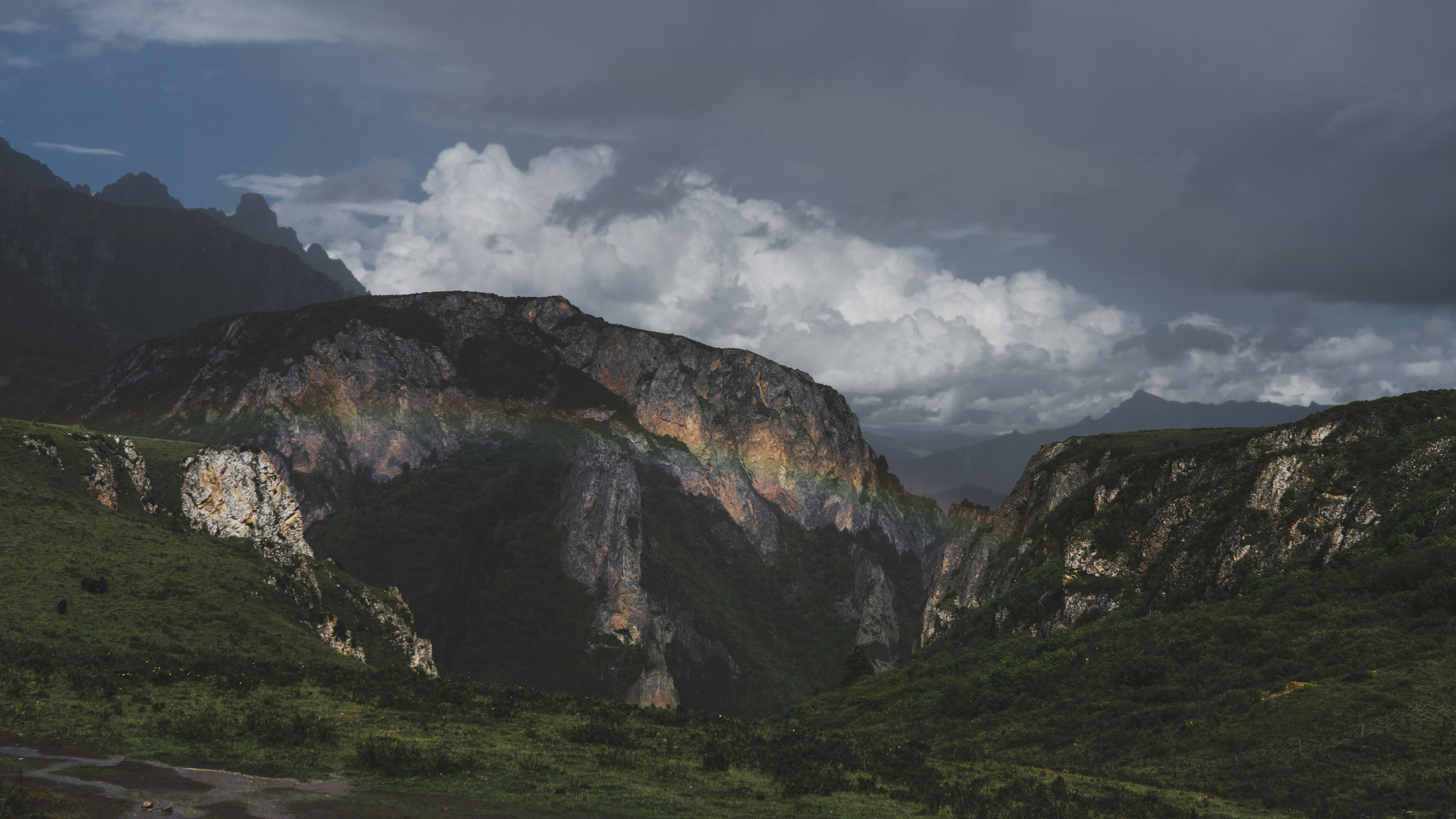 a rainbow in the sky over a mountain range