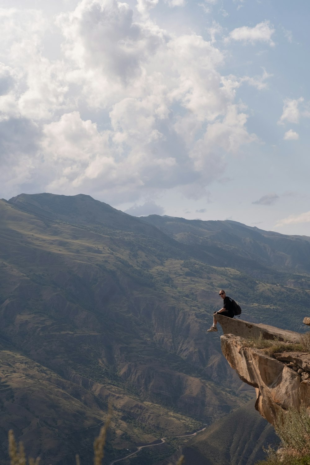 a person sitting on a rock overlooking a valley