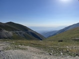 A serene landscape with a winding road leading to distant mountains.