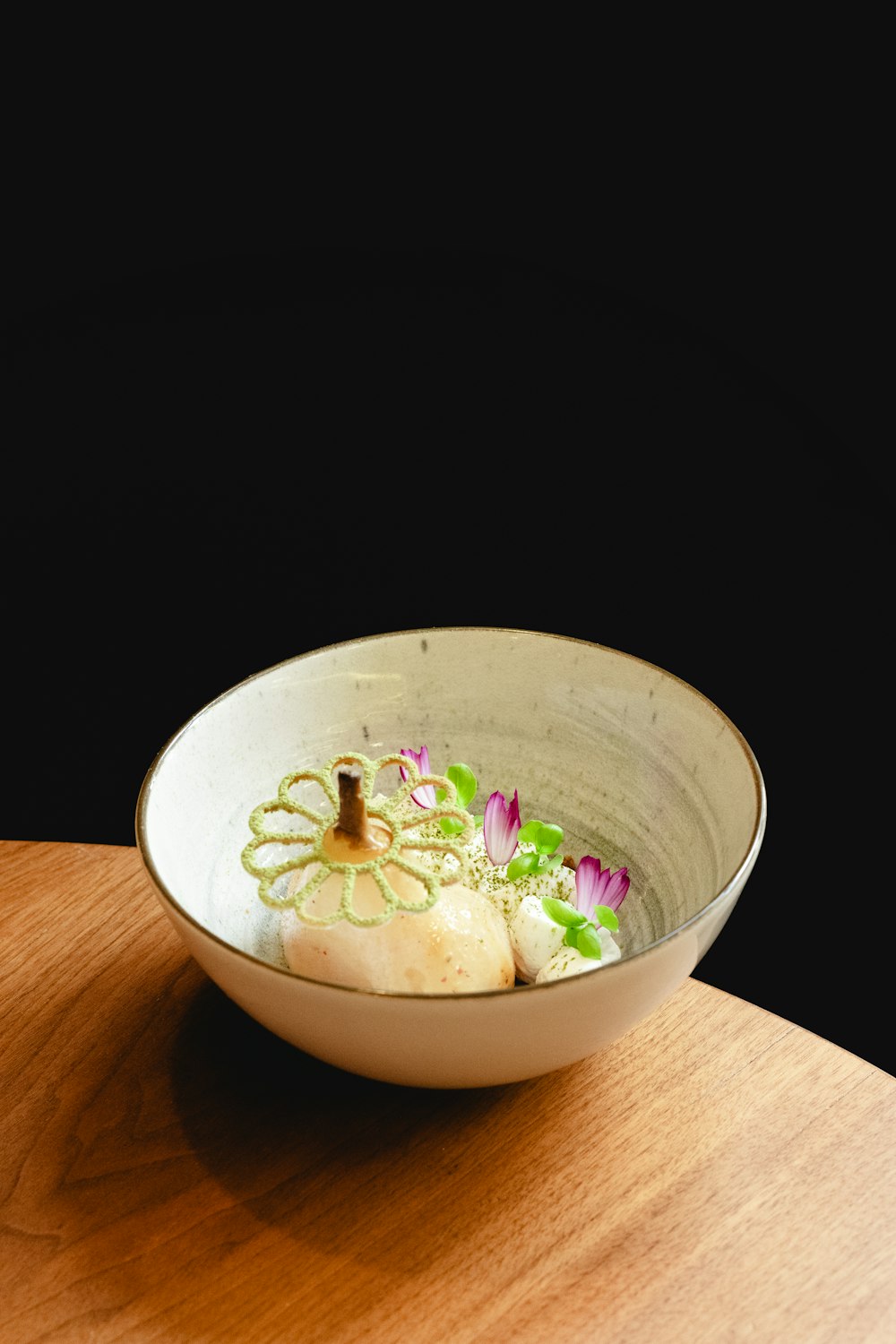 a white bowl filled with food on top of a wooden table