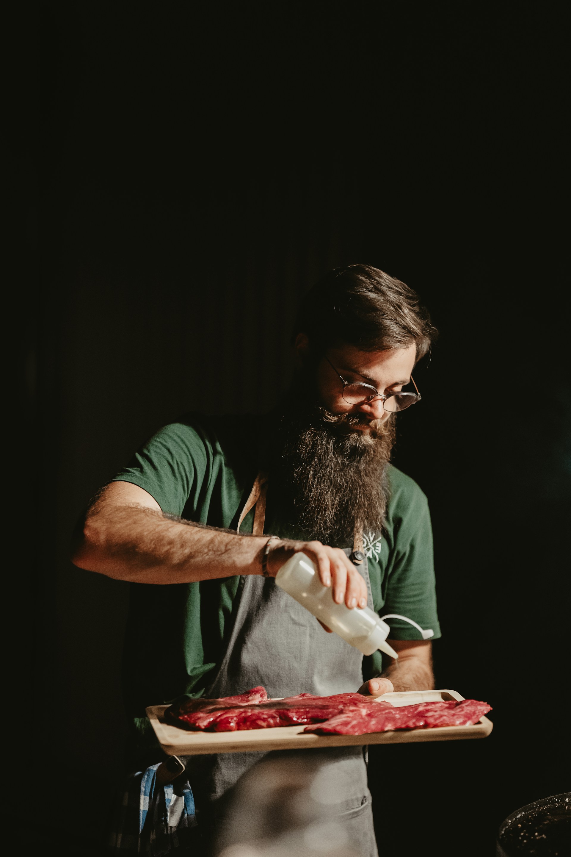 a man with a long beard is pouring something into a tray