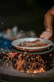 a person holding a plate of food over a fire