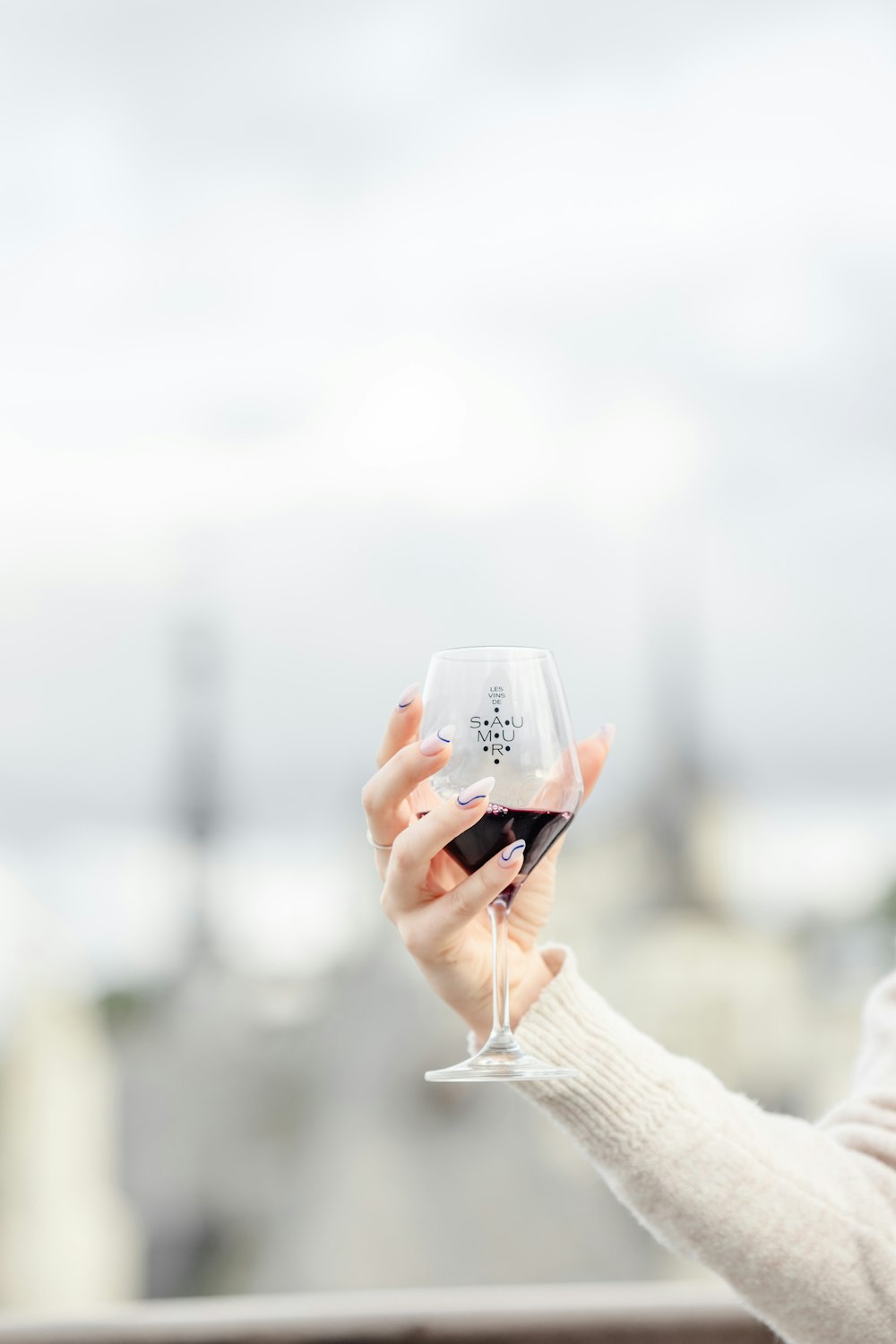 a woman holding a wine glass in her hand