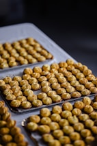 Rows of freshly baked pastries lined up neatly on a rustic wooden shelf.