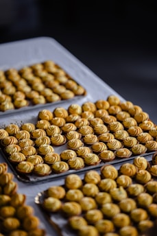 Rows of freshly baked pastries lined up neatly on a rustic wooden shelf.