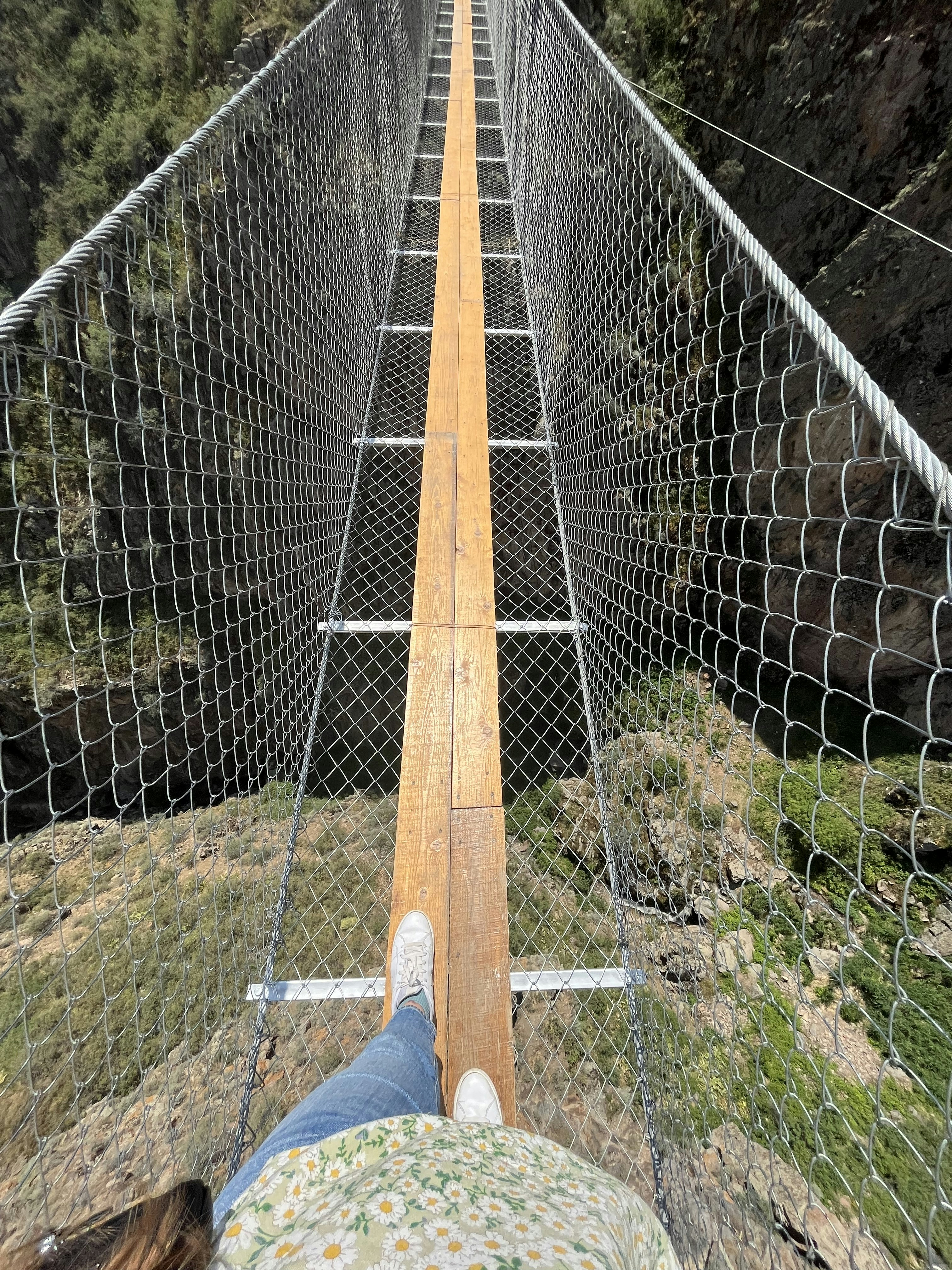 a person is sitting on a rope bridge