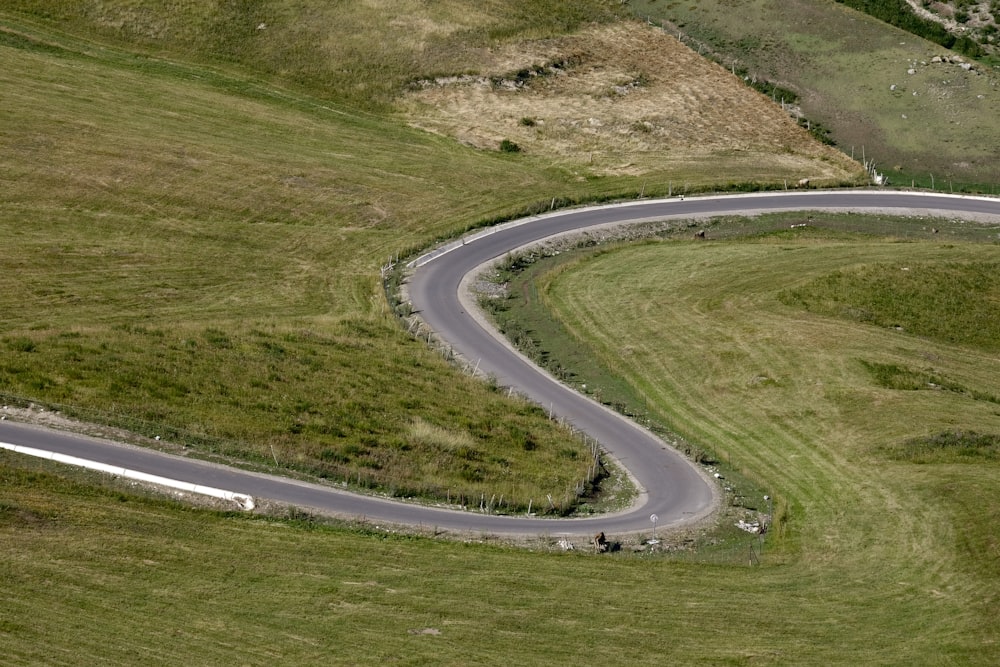 a winding road in the middle of a grassy field
