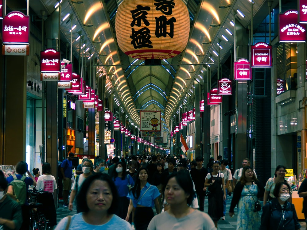 a group of people walking down a street next to tall buildings