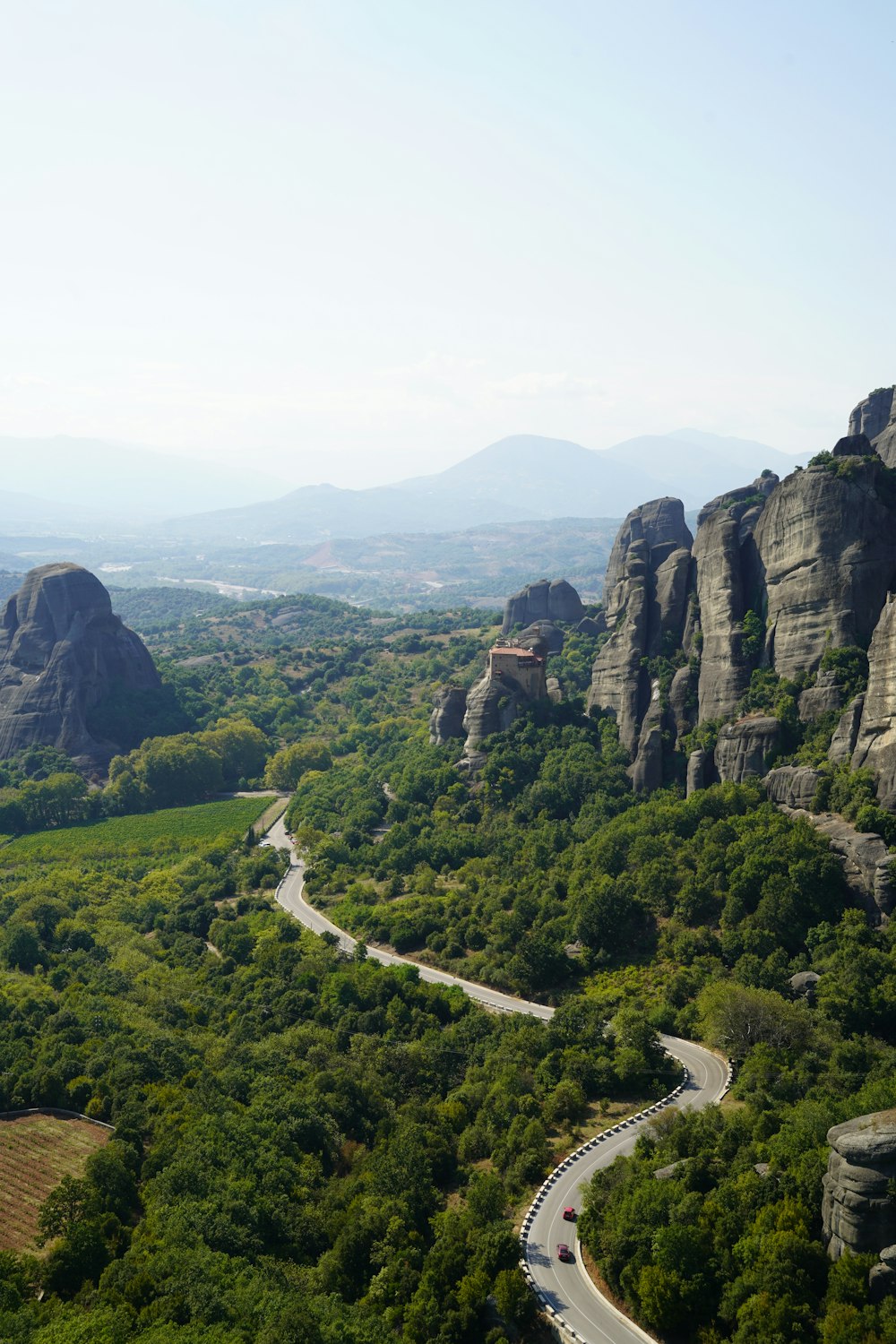 a road winding through a lush green valley