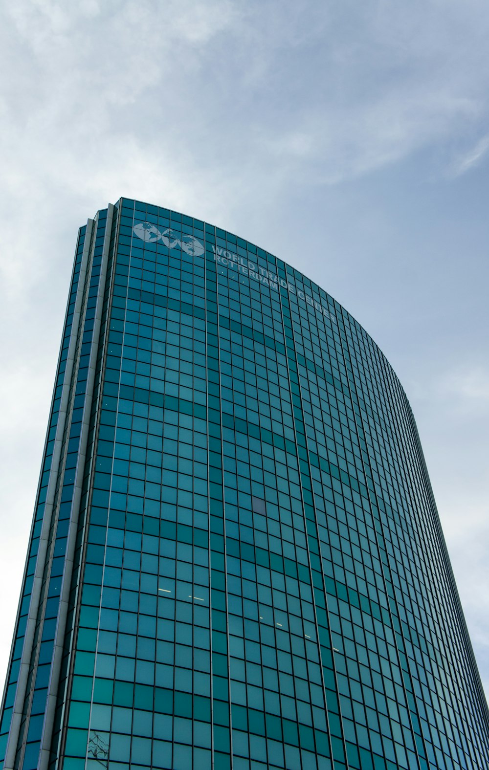 a tall glass building with a sky background