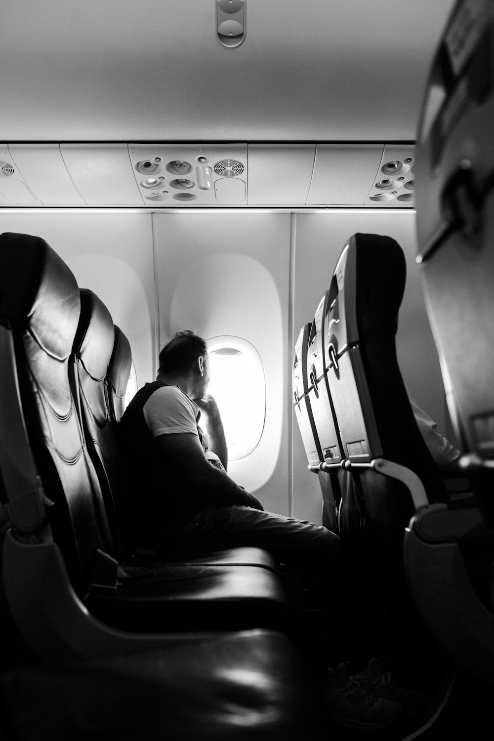 um homem sentado em um assento em um avião