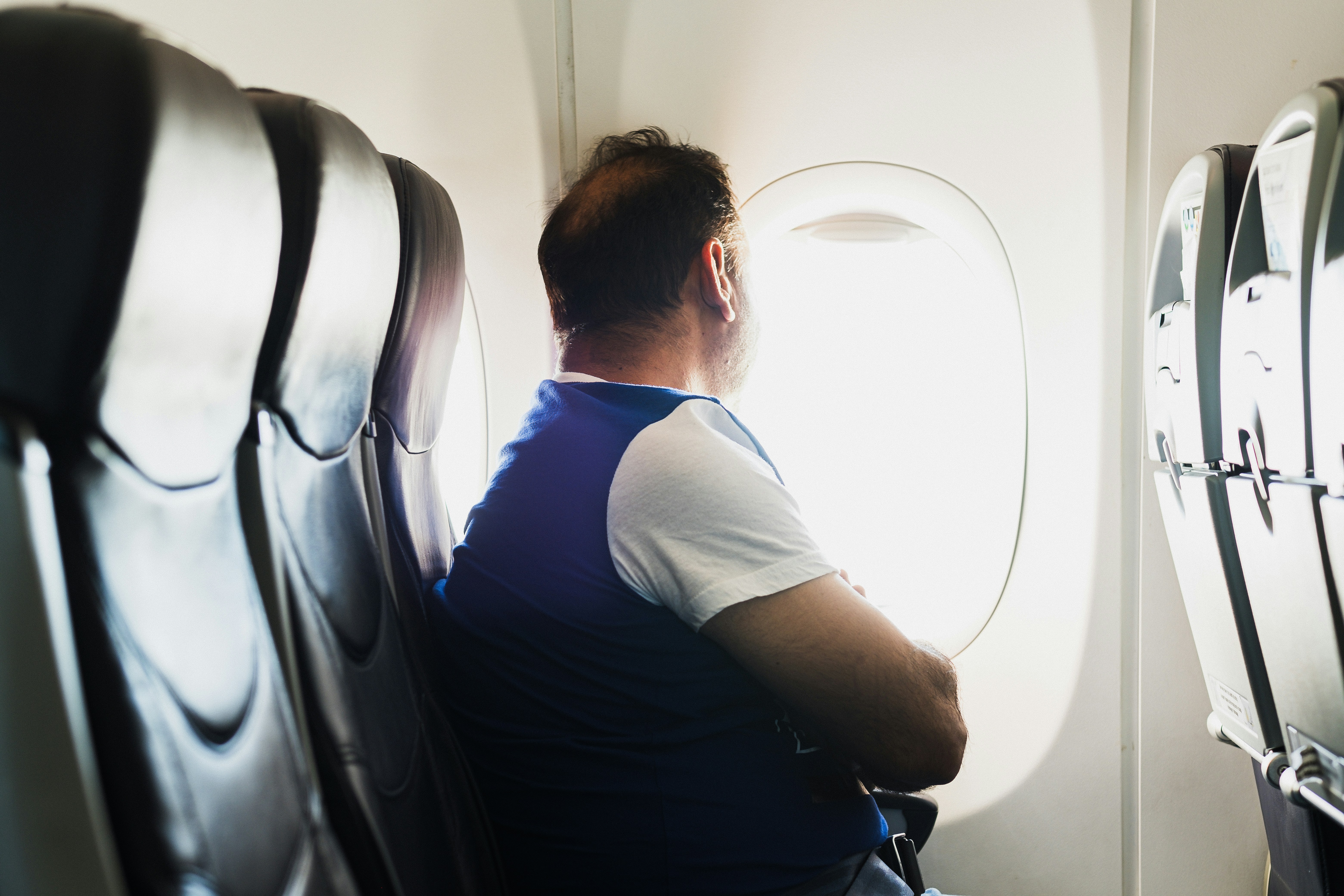 traveler looking out the airplane window during a long-haul flight