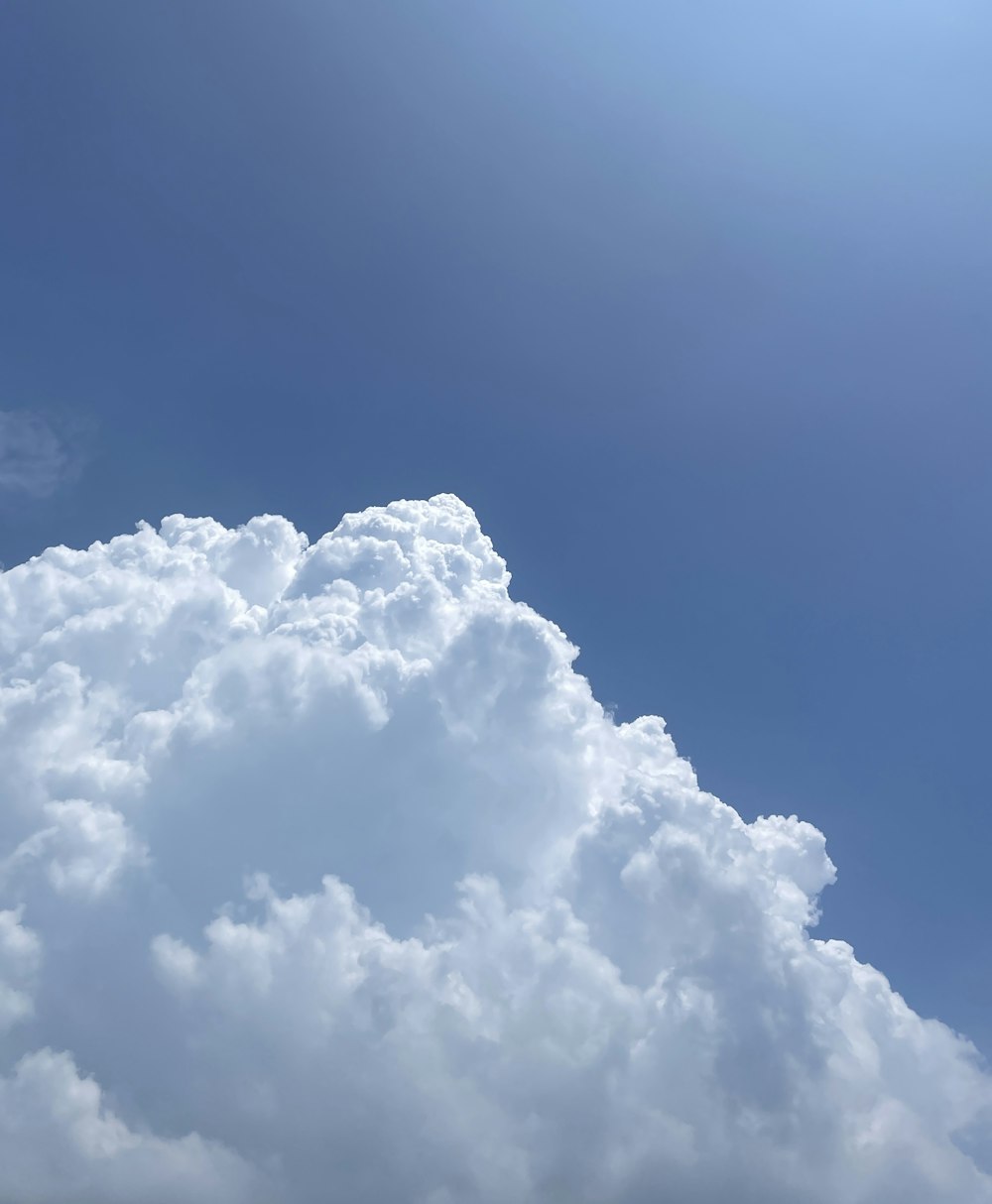 a plane flying through a cloud filled sky