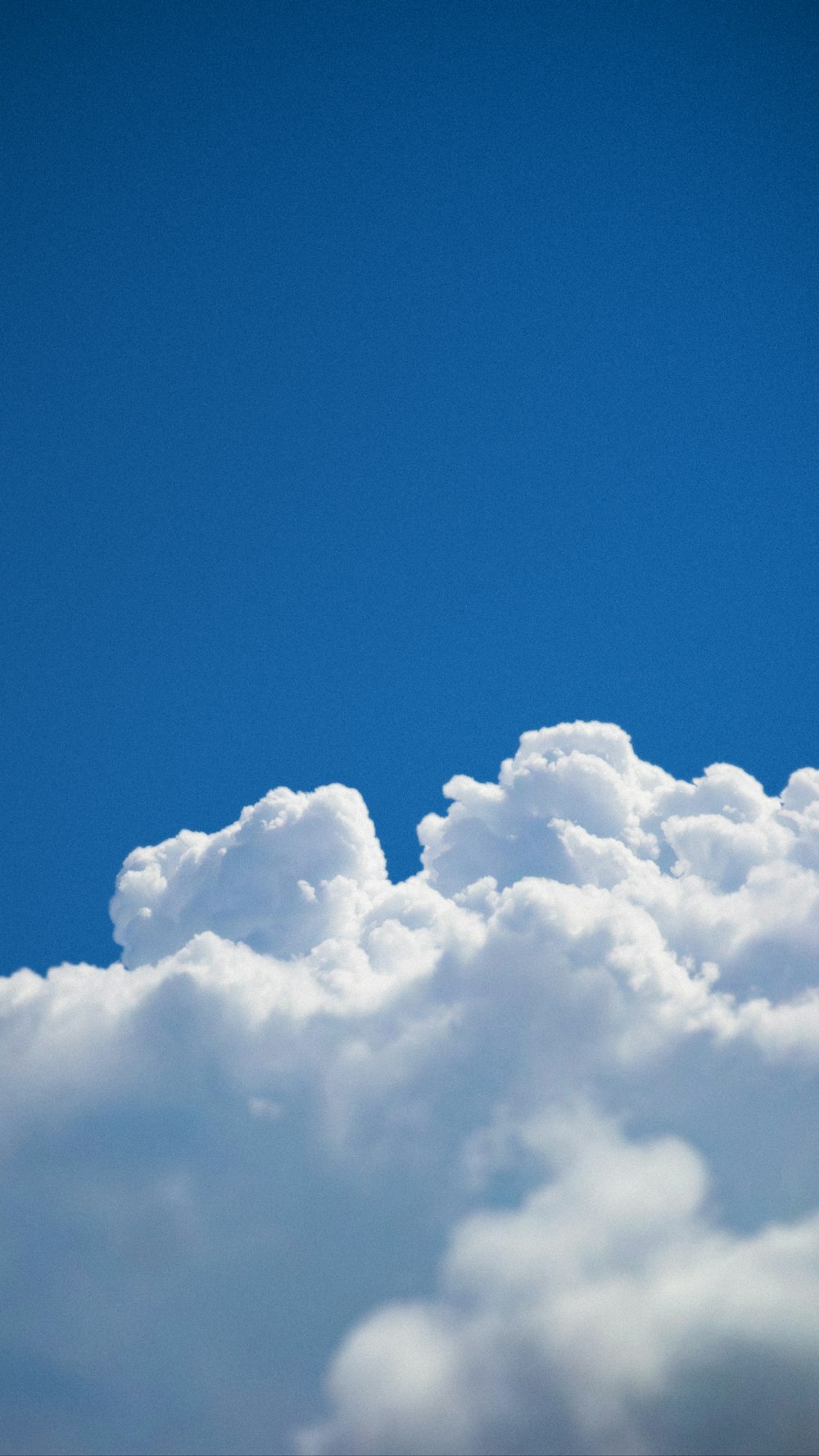 a plane flying through a cloud filled sky