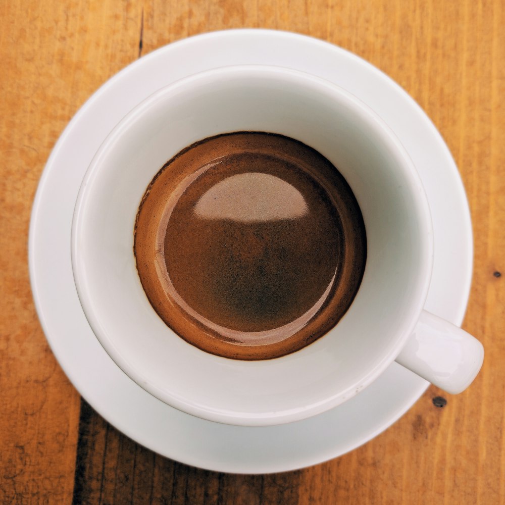 a close up of a cup of coffee on a wooden table