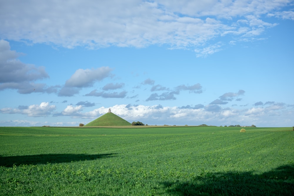 un campo verde con una collina sullo sfondo