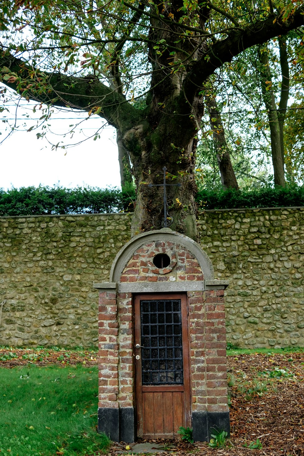 a small brick building with a tree in the background