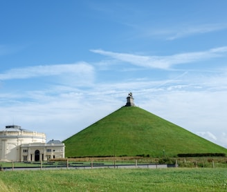 a large grassy hill with a building in the background