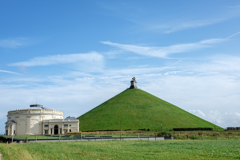 a large grassy hill with a building in the background