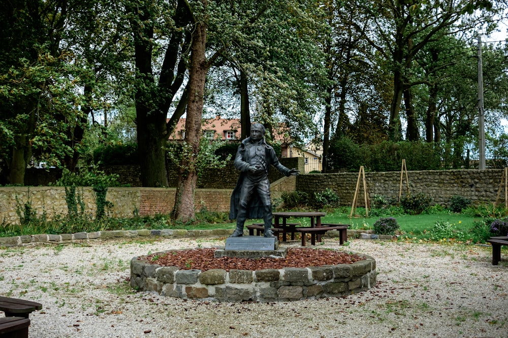 a statue of a man in a park setting
