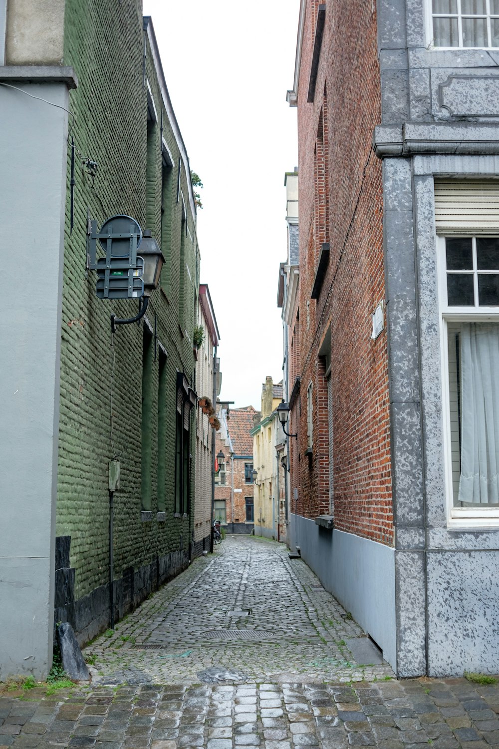 a narrow alley way with brick buildings on both sides