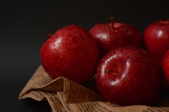 a group of red apples sitting on top of a cloth