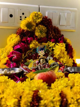 An ornate silver plate holding offerings for the Kankali Maa Puja, surrounded by marigold flowers.