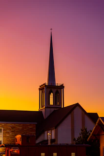 a church with a steeple at sunset