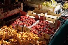 a fruit stand with strawberries and other fruits