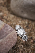 a close up of a diamond ring on a rock