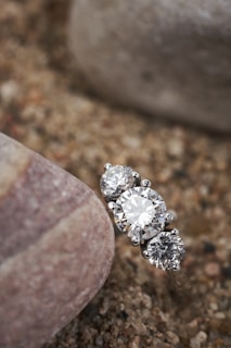 a close up of a diamond ring on a rock