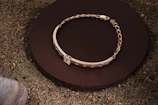 Elegant 18k gold bracelet with intricate design displayed on a marble surface.