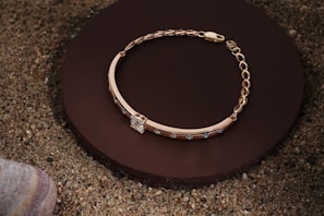 Close-up of elegant gold and earth-toned bracelets arranged on a wooden surface