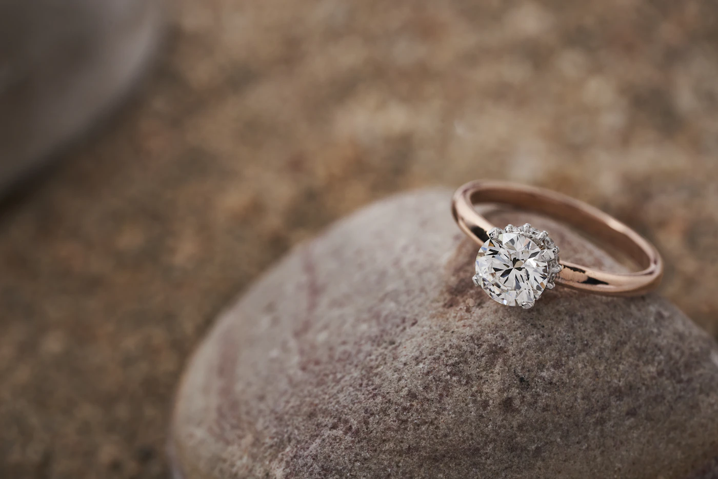 Rose gold diamond solitaire engagement ring photographed in soft natural light